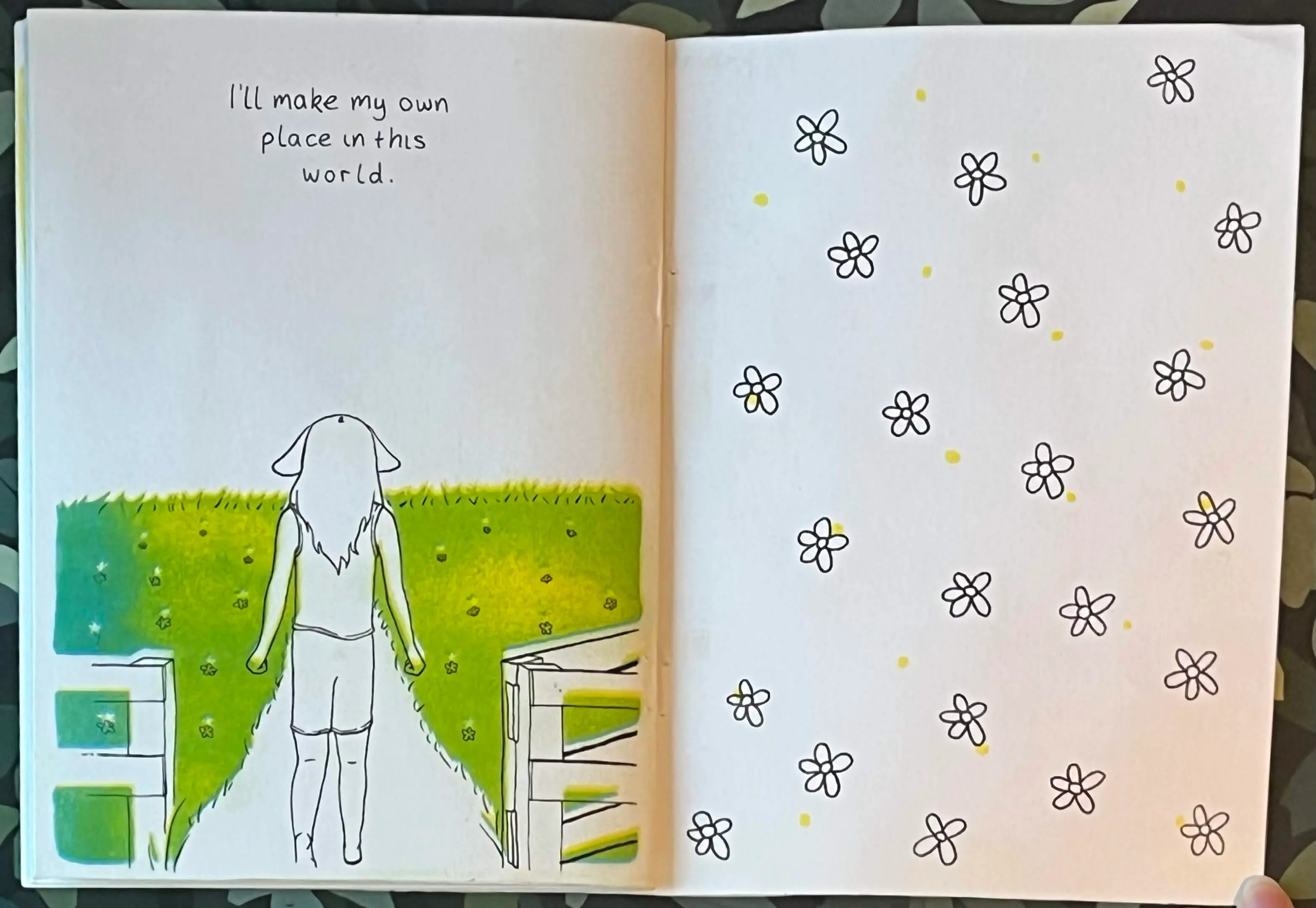Pages 13 and 14 Black Sheep, showing sheep girl staring at a field standing in an open gate with text 'I'll make my own place in this world' on the first page. And some flowers on the second page, mirroring page 1.